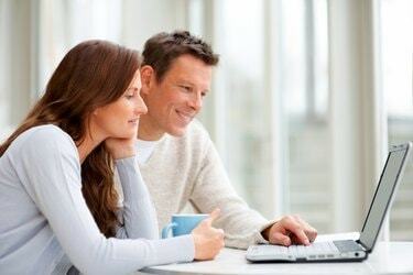 Casal usando laptop e sorrindo