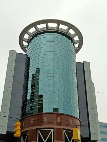 Foto ampliada de um edifício circular de vidro.