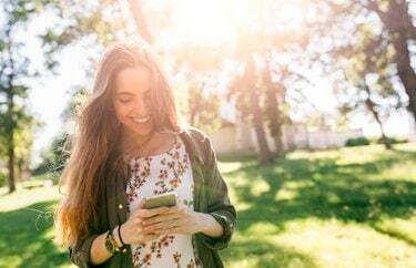 Mladá žena odesílání zpráv se svým smartphonem