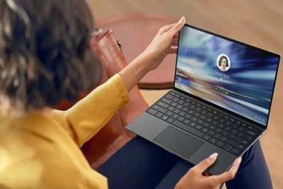 Osoba sedící a držící notebook Dell XPS 13 na klíně.