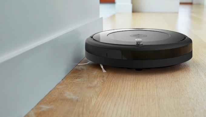 Un iRobot Roomba 694 accanto a un muro mentre aspira i peli degli animali domestici.