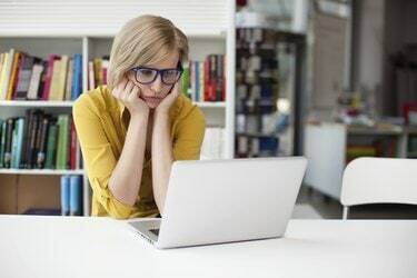 Overwerkte droevige vrouw die in bibliotheek werkt