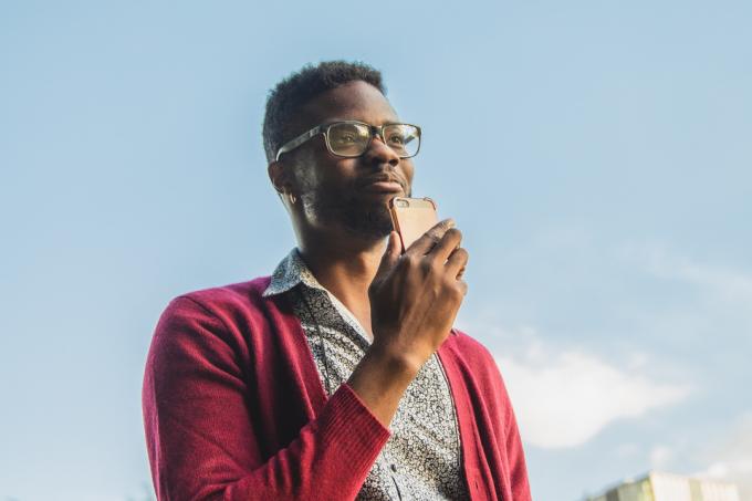 En mand bruger en smartphone på gaden.