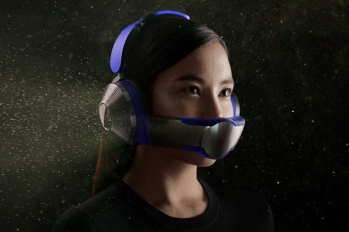 Una mujer usa los auriculares purificadores de aire Dyson Zone sobre un fondo negro lleno de partículas de polvo.