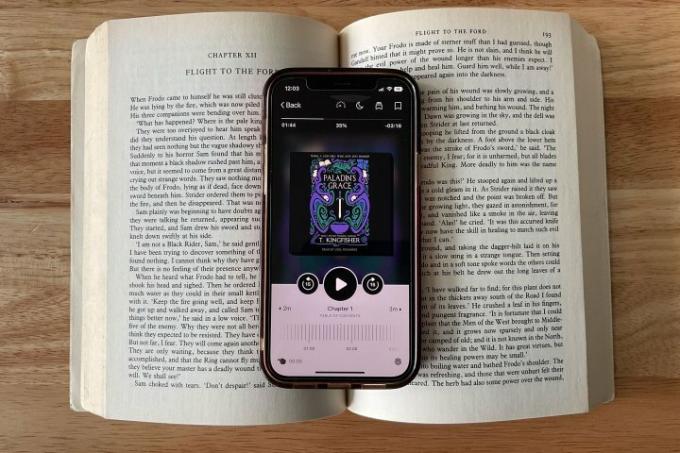 O aplicativo Libby exibido em um iPhone 12 apoiado em um livro aberto.