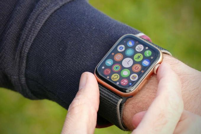 O Apple Watch SE, no pulso. A tela de seleção de aplicativos está sendo exibida.