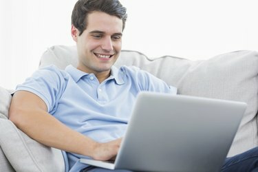 Patrauklus vyras, naudojantis savo nešiojamąjį kompiuterį