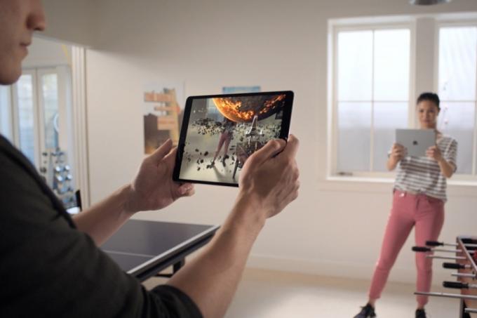 Dua orang memainkan game augmented reality di Apple iPad.