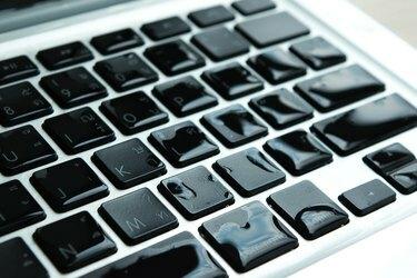 Computador portátil com gota de água, líquido danificado e derrame no teclado