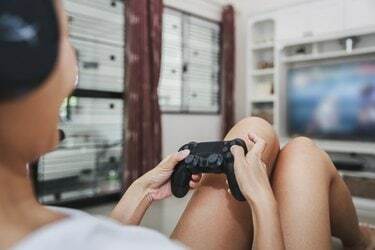 Mulher asiática joga videogame em casa