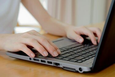 노트북으로 타이핑하는 프로그래머의 손. 그의 손가락에 초점