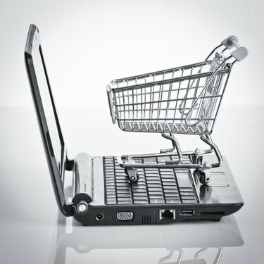 Online nakupování. Nákupní košík s notebookem na bílé. shopp