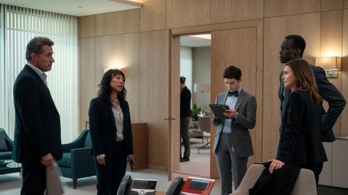 Un grupo de funcionarios se encuentra en una oficina hablando en una escena de The Diplomat en Netflix.
