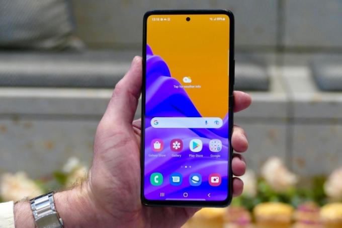 Uma mão segura o Samsung Galaxy A53 com a tela 5G à mostra.