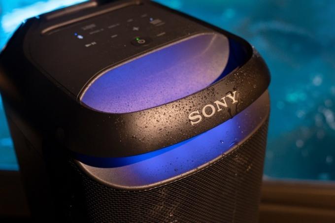 Dessus du Sony SRS-XV800 avec des gouttes d'eau et des lumières allumées.