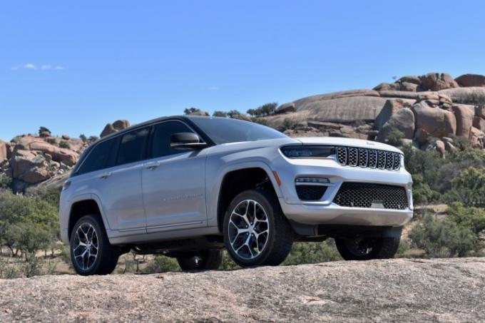 O híbrido plug-in Jeep Grand Cherokee 4xe 2022 empoleirado em uma rocha.