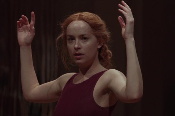 Dakota Johnson zvedla ruce ve filmu Suspiria (2018).