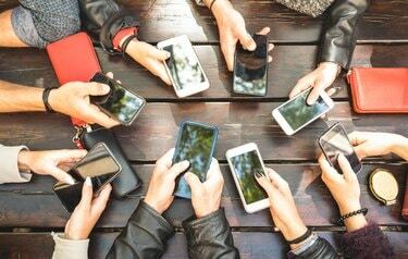 ხალხის ჯგუფი, რომელიც ერთად მხიარულობს სმარტფონების გამოყენებით - ხელების დეტალები, რომლებიც აზიარებენ კონტენტს სოციალურ ქსელში მობილური სმარტფონებით - ტექნოლოგიის კონცეფცია ათასწლეულებთან ონლაინ მობილური ტელეფონებით