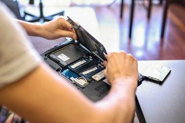 Close de mãos trabalhando em um laptop na sala de estar