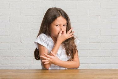 Mladá dívka drží nos