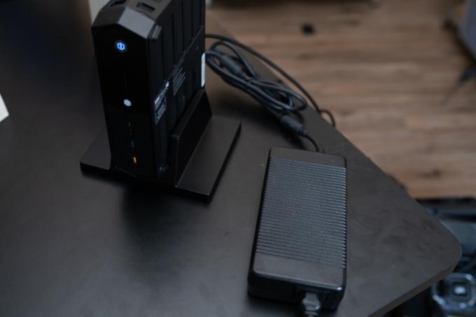 Intel NUC 12 Enthusiast sjedi pokraj svoje opeke za napajanje.