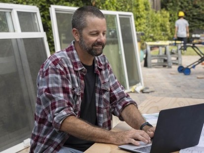 Un bărbat care folosește software-ul QuickBooks pe un laptop.