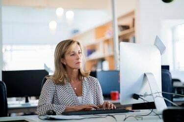 Femme d'affaires confiante à l'aide d'un ordinateur au bureau