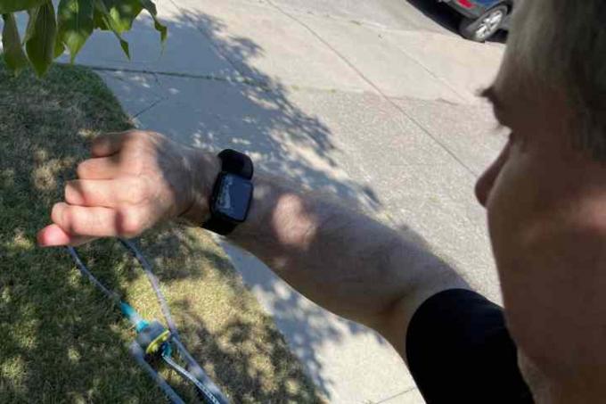 Orang yang memegang Apple Watch dengan Wristcam untuk panggilan video.