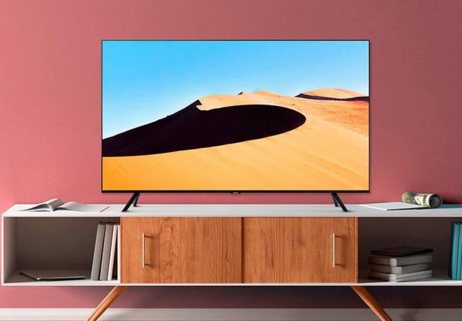 De Samsung TU69OT 4K Smart TV op een mediakast in een woonkamer.