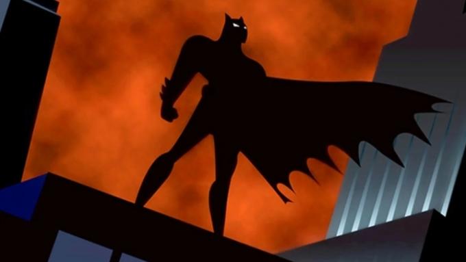 A silhueta de Batman no topo de um prédio em Gotham.