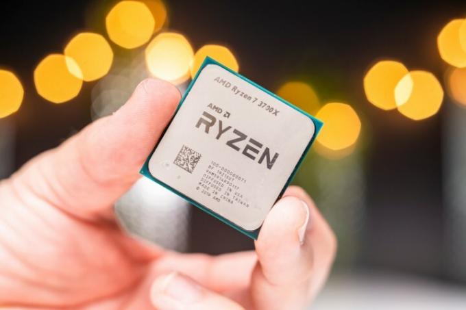 Un AMD Ryzen 7 3700X ținut între vârfurile degetelor unei persoane. 