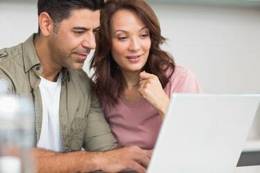 Couple utilisant un ordinateur portable dans la cuisine