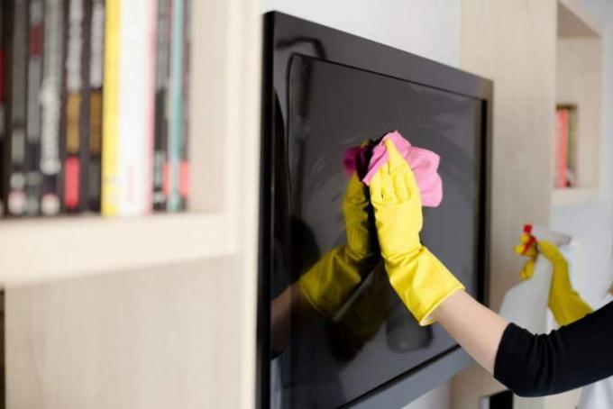 jak wyczyścić ekran telewizora 58617618 kobieta w żółtych gumowych rękawiczkach czyści różową szmatką 768x768
