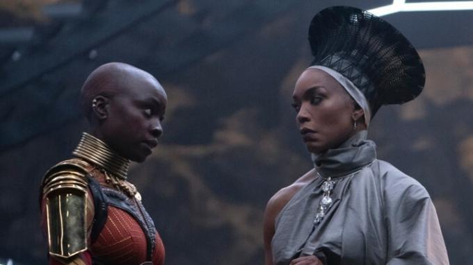 Danai Gurira ir Angela Bassett įdėmiai žiūri vienas į kitą scenoje iš Juodosios pantera: Wakanda Forever.