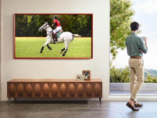 Et Samsung The Frame TV, der viser en person, der rider på en hest og spiller polo.