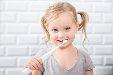 Anak menggunakan sikat gigi Kolibree