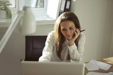 Mooie jonge vrouw die vanuit huis werkt met behulp van laptop