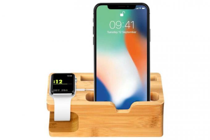 Zdjęcie przedstawia iPhone'a i Apple Watch w bambusowej stacji dokującej