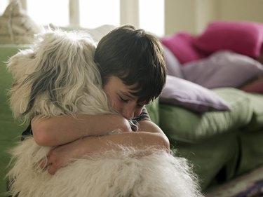彼の犬を抱き締める少年