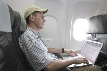 Passager med bærbar computer i fly