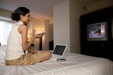 Affärskvinna på hotellsäng tittar på finansiella nyheter
