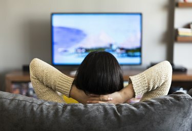 jonge vrouw die televisie kijkt