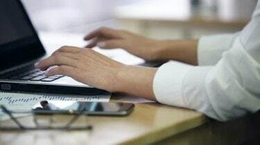 Руки сотрудницы женского офиса, печатающей на ноутбуке, вводят данные обследования, крупным планом
