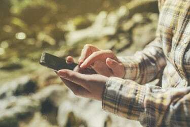 תיירת משתמשת בטלפון חכם נייד עבור ניווט GPS