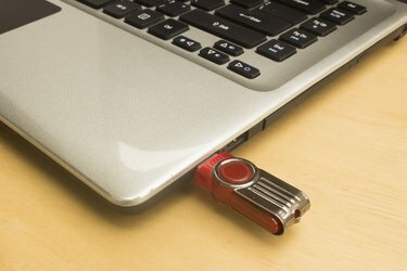 nešiojamas kompiuteris ir „flash drive“.