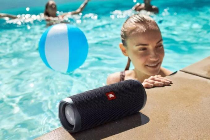 Колонка JBL Flip 5 bluetooth на краю басейну.