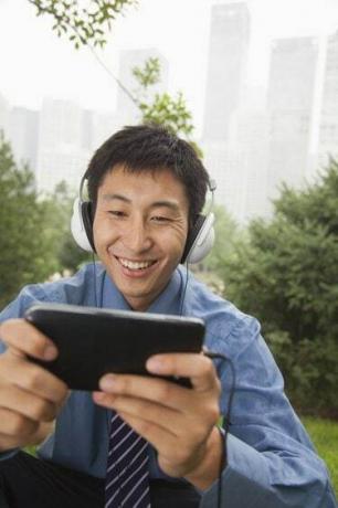 Jonge zakenman die naar muziek luistert op zijn MP4-speler