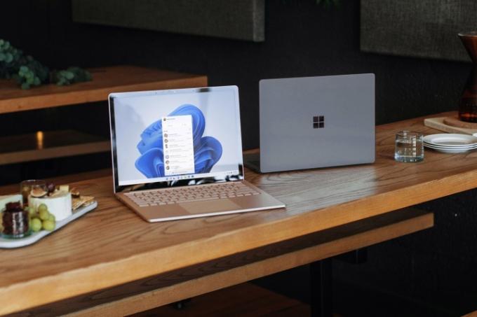 Dva notebooky Windows sedí na dřevěném stole.