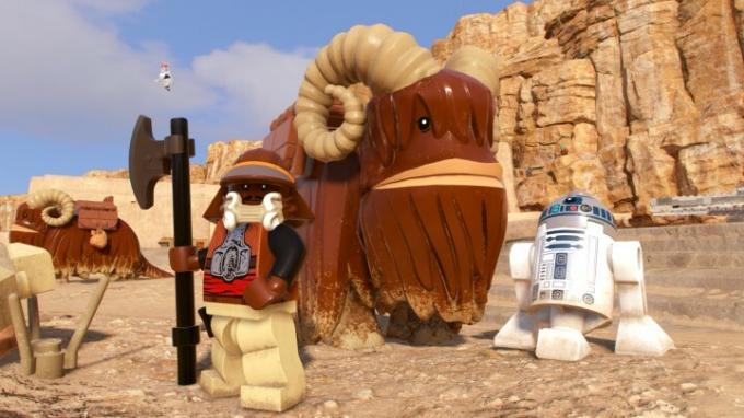 Lando in R2D2 stojita ob strani Bantha v Lego Star Wars: The Skywalker Saga.