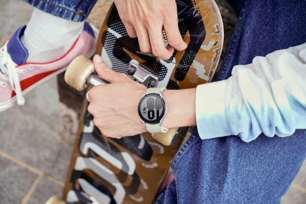 Person, der holder skateboard, mens han har Samsung Galaxy Watch 4 på.